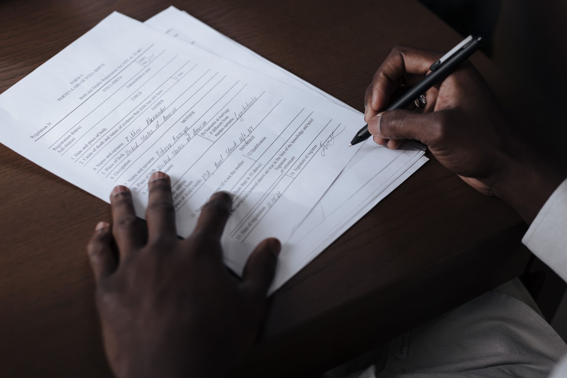 Person signing a paper document
